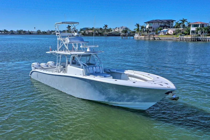 Slide: The Image of 2015 Yellowfin 42 Offshore boat on calm water near waterfront homes. - 2