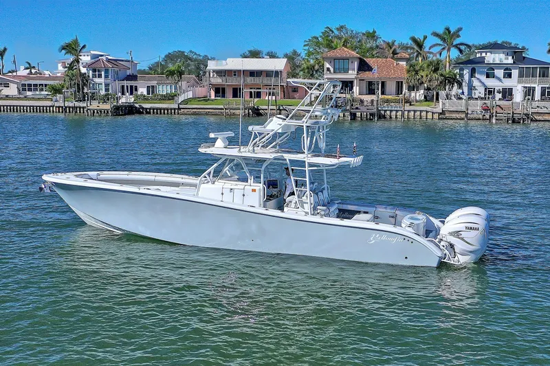 Slide: The Image of 2015 Yellowfin 42 Offshore boat on water, with coastal homes in the background. - 3