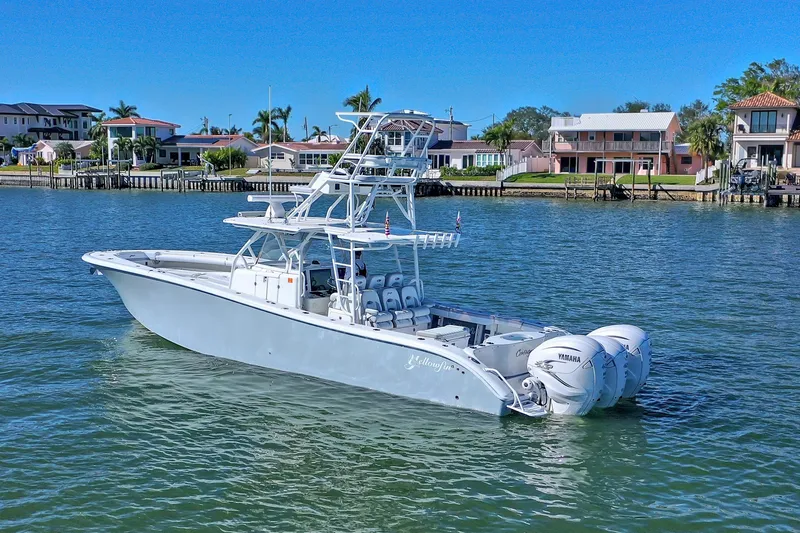 Slide: The Image of 2015 Yellowfin 42 Offshore boat with Yamaha XTO Offshore engines, docked by waterfront homes. - 4
