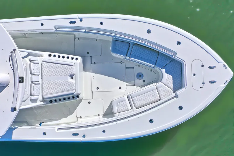 Slide: The Image of 2015 Yellowfin 42 Offshore boat, aerial view, spacious deck, white seating, green water background. - 9