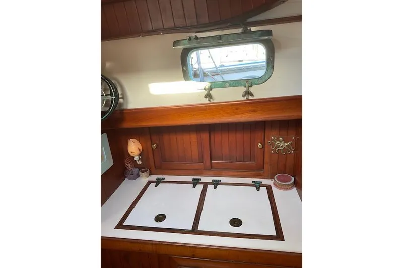 Slide: The Image of Interior of 1983 Vagabond 42 sailboat with wooden cabinetry and porthole window. - 11