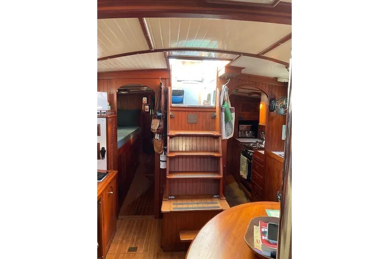 Slide: The Image of Interior of 1983 Vagabond 42 sailboat with wooden cabinetry and cozy living space. - 13
