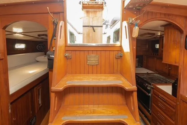 Slide: The Image of Interior of 1983 Vagabond 42 sailboat with wooden stairs and cozy cabin layout. - 14