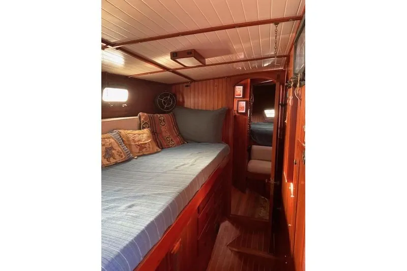 Slide: The Image of Cozy cabin interior of 1983 Vagabond 42 sailboat with wooden finish and comfortable bedding. - 15