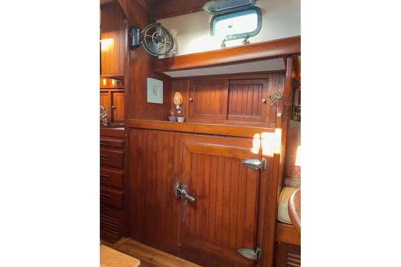 Slide: The Image of Interior of 1983 Vagabond 42 sailboat with wooden cabinetry and nautical decor. - 16