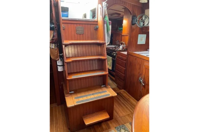 Slide: The Image of Interior of 1983 Vagabond 42 sailboat with wooden stairs and galley kitchen. - 3