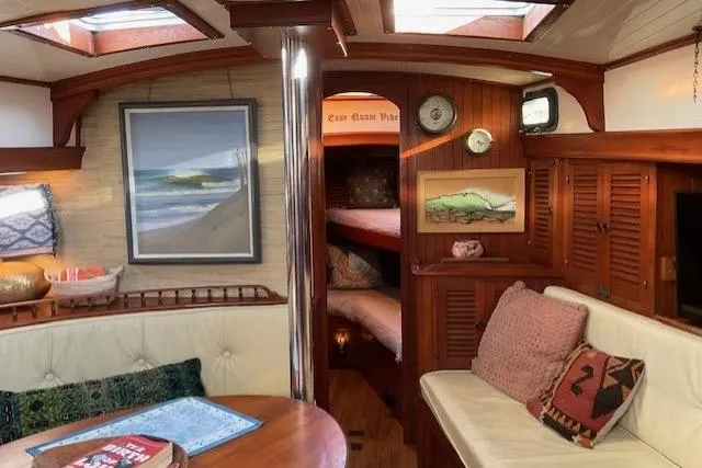 Slide: The Image of Cozy 1983 Vagabond 42 yacht interior with wood paneling, seating, and nautical decor. - 4