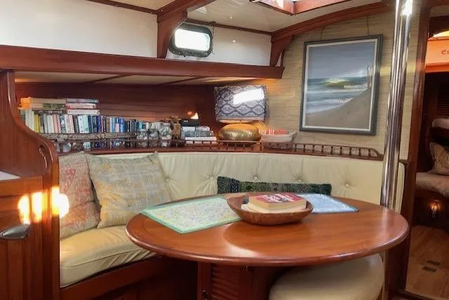 Slide: The Image of Cozy interior of 1983 Vagabond 42 sailboat with books, seating, and nautical decor. - 5