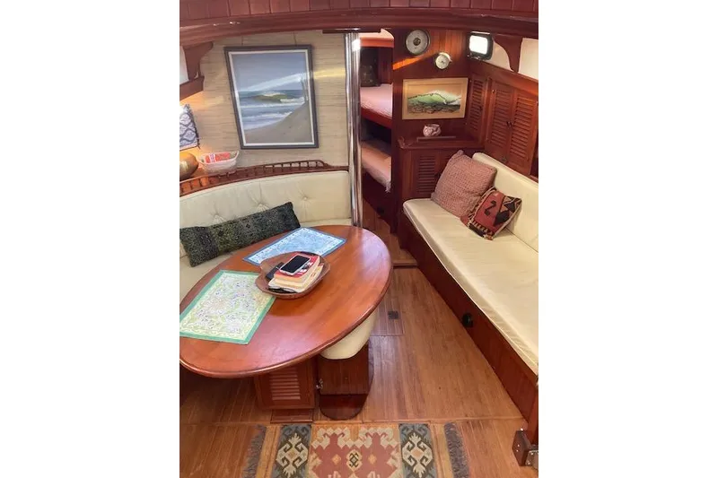 Slide: The Image of Cozy interior of 1983 Vagabond 42 sailboat with wooden furnishings and nautical decor. - 6