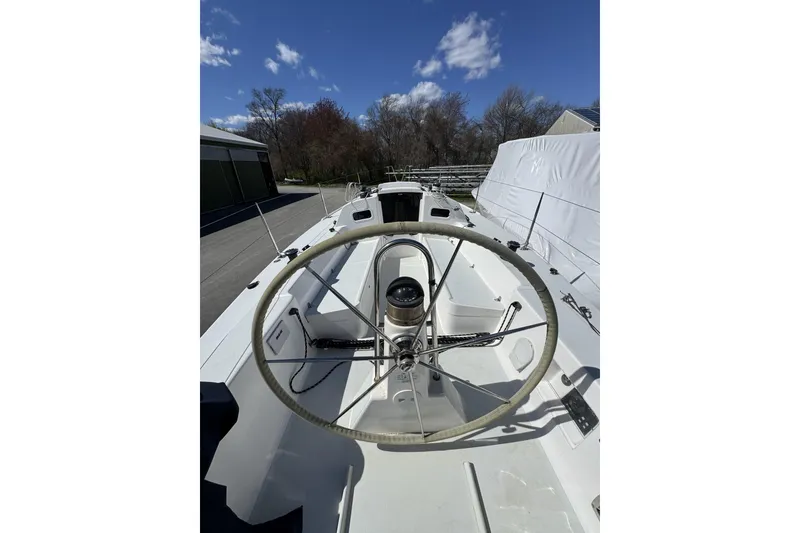Slide: The Image of 2011 J Boats J/95 sailboat cockpit with steering wheel, under clear blue sky. - 23