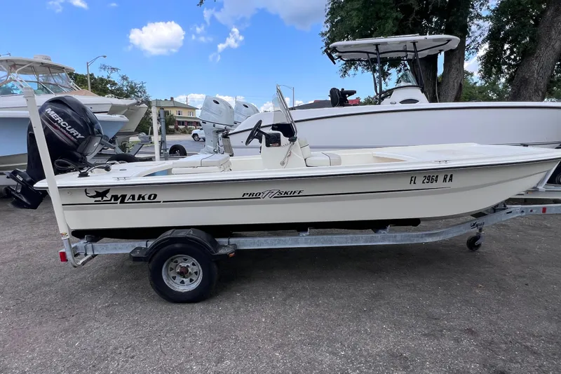 The Image of 2016 Mako Pro Skiff 17 CC boat on trailer, parked outdoors under blue sky. - 0
