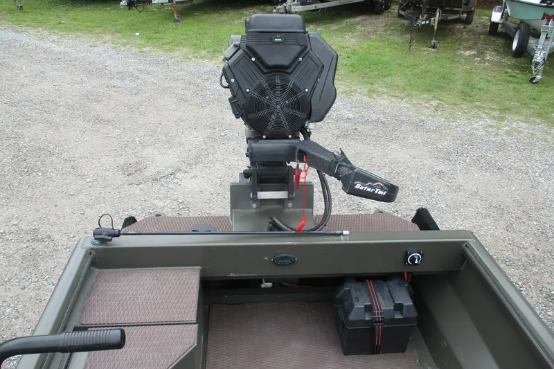Slide: The Image of 2024 Gator Tail 1848 Gator Series boat with powerful engine, parked on gravel. - 2