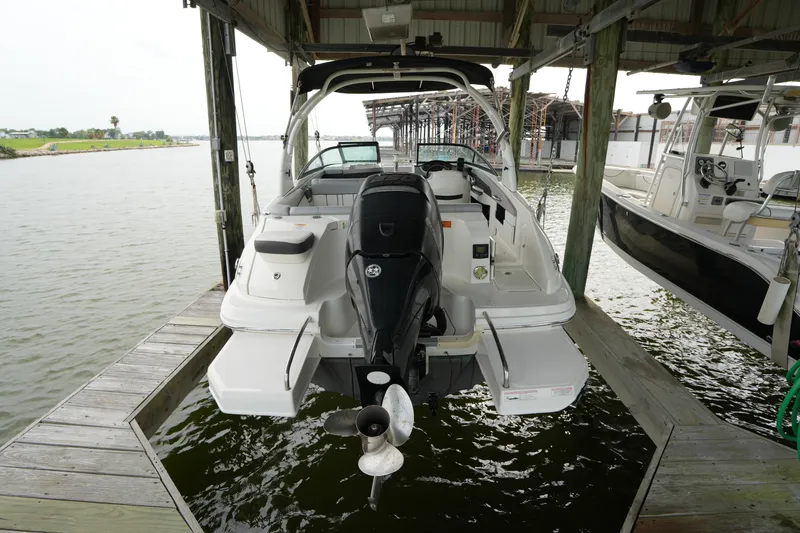 Slide: The Image of 2017 Sea Ray 240 Sundeck docked, showcasing rear view and outboard motor. - 4