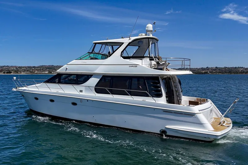 Slide: The Image of 2003 Carver 530 Voyager Pilothouse yacht cruising on open water under clear skies. - 19