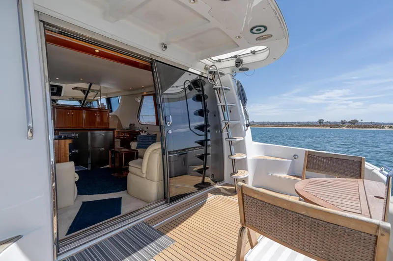 Slide: The Image of 2003 Carver 530 Voyager Pilothouse yacht interior with open deck, ocean view, and elegant seating. - 23