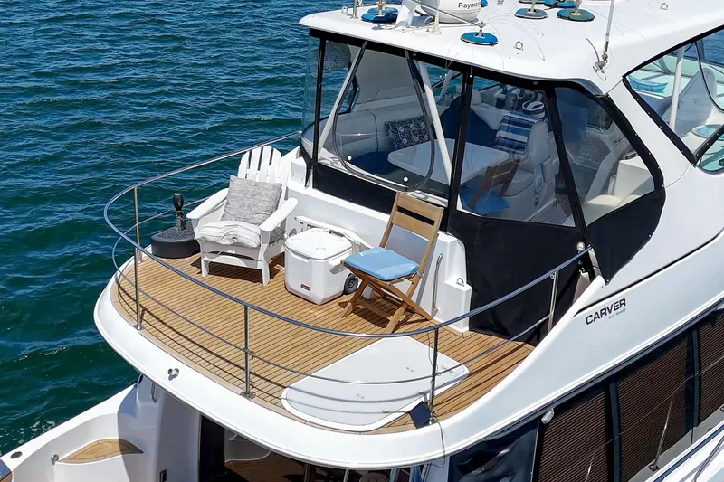 Slide: The Image of 2003 Carver 530 Voyager Pilothouse yacht with spacious deck and seating on water. - 26