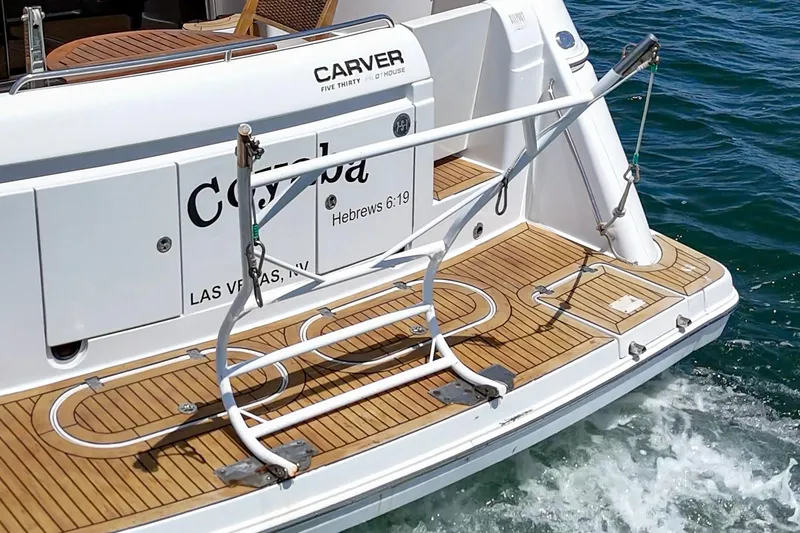 Slide: The Image of 2003 Carver 530 Voyager Pilothouse yacht with teak swim platform on water. - 28