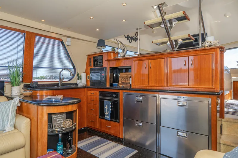Slide: The Image of Luxurious 2003 Carver 530 Voyager Pilothouse interior with modern kitchen and elegant wood cabinetry. - 52