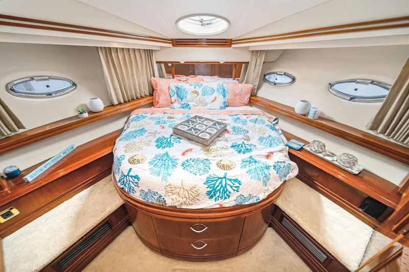 Slide: The Image of Luxurious 2003 Carver 530 Voyager Pilothouse bedroom with nautical-themed bedding and elegant decor. - 63