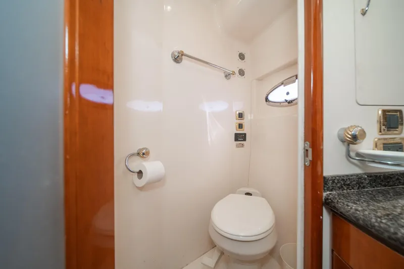 Slide: The Image of Bathroom interior of 2003 Carver 530 Voyager Pilothouse yacht, featuring toilet and porthole window. - 68