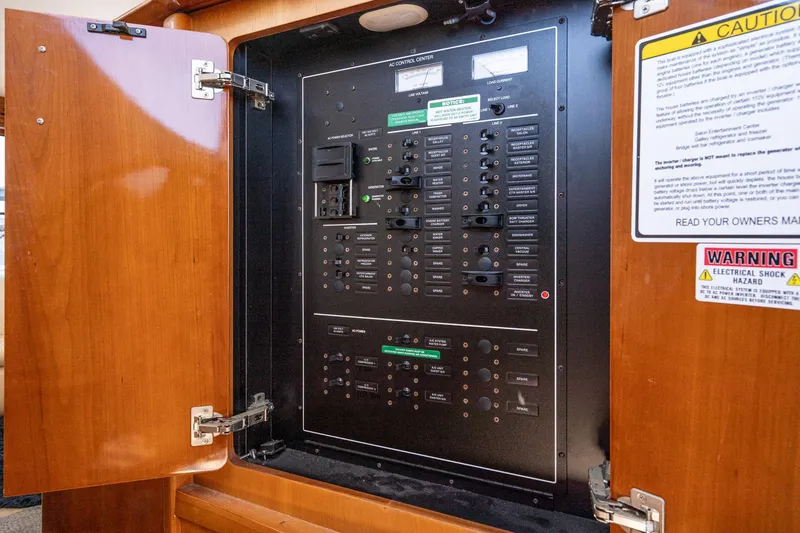 Slide: The Image of Electrical control panel inside 2003 Carver 530 Voyager Pilothouse yacht, featuring safety warnings. - 69