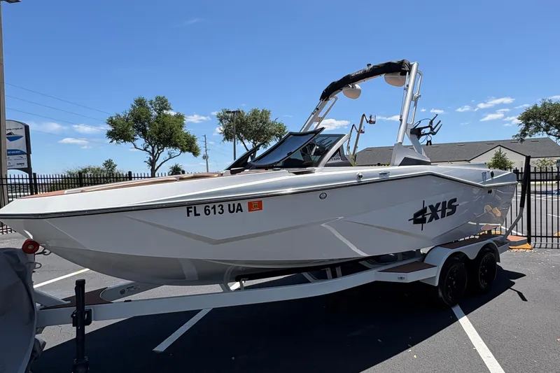 The Image of 2025 Axis T220 boat on trailer in sunny parking lot. - 0