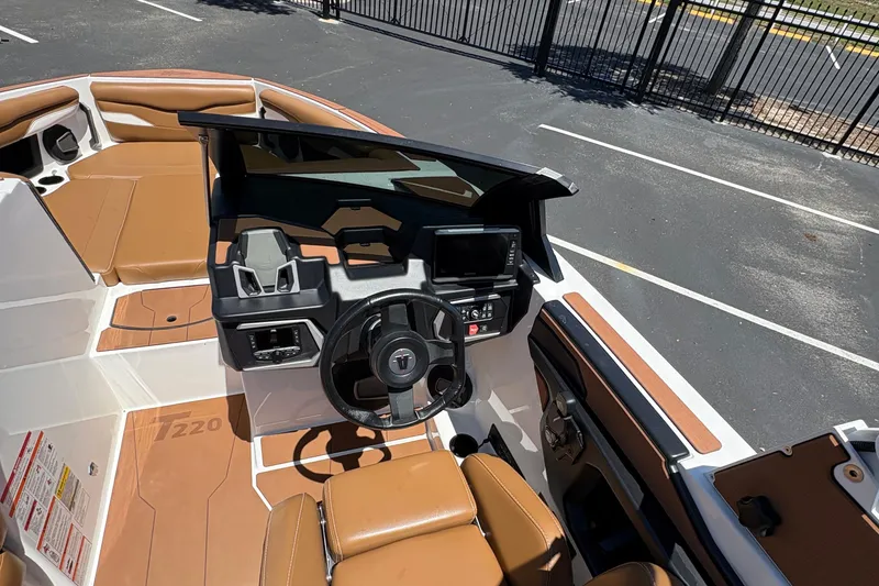 Slide: The Image of 2025 Axis T220 boat interior with tan seating and modern dashboard controls. - 5