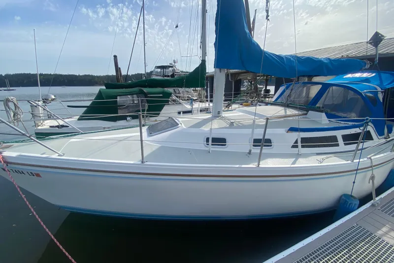 The Image of 1987 Catalina 30 MkII sailboat docked at marina under clear sky. - 0
