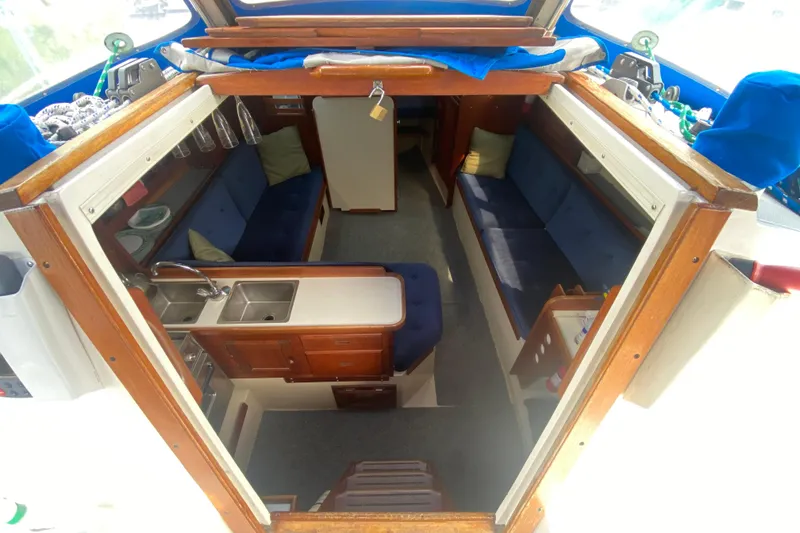 Slide: The Image of Interior of 1987 Catalina 30 MkII sailboat with cozy seating and compact kitchen area. - 11