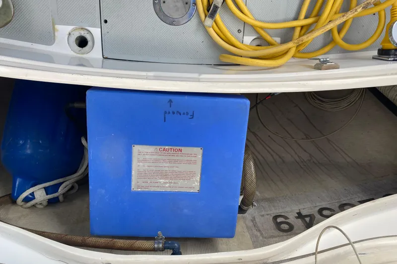 Slide: The Image of 1987 Catalina 30 MkII boat compartment with blue tank, yellow cables, and caution label. - 14