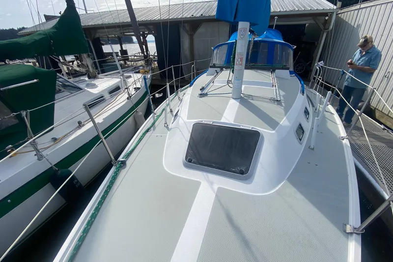 Slide: The Image of 1987 Catalina 30 MkII sailboat docked, featuring a clean deck and blue sail cover. - 2