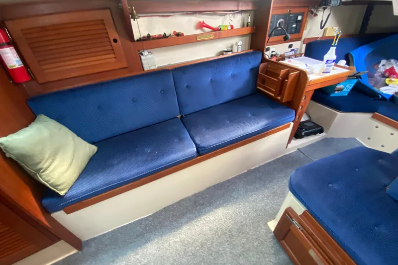 Slide: The Image of Interior of a 1987 Catalina 30 MkII sailboat with blue seating and wooden accents. - 21