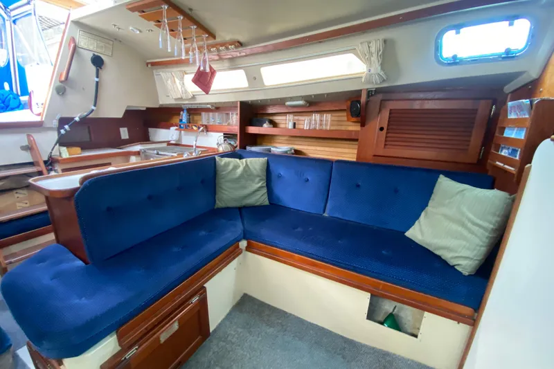 Slide: The Image of Interior of 1987 Catalina 30 MkII sailboat with blue cushioned seating and wooden accents. - 22