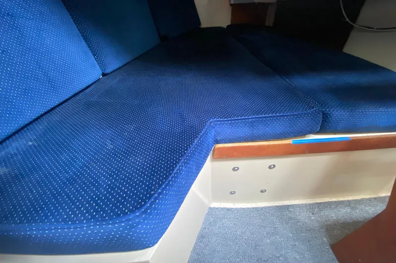 Slide: The Image of Blue cushioned seating inside a 1987 Catalina 30 MkII sailboat cabin. - 23