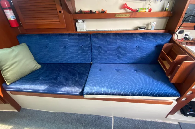 Slide: The Image of Blue cushioned seating area inside a 1987 Catalina 30 MkII sailboat cabin. - 25