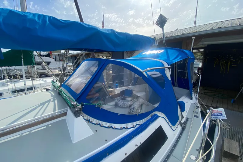 Slide: The Image of 1987 Catalina 30 MkII sailboat with blue canopy docked at marina. - 4