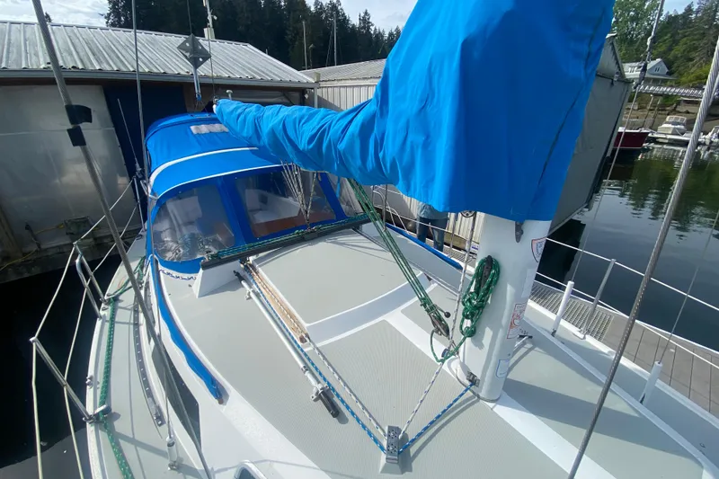 Slide: The Image of 1987 Catalina 30 MkII sailboat with blue sail cover docked at marina. - 6