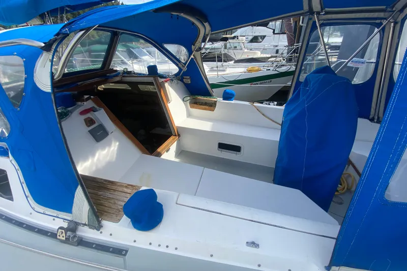 Slide: The Image of 1987 Catalina 30 MkII sailboat cockpit with blue canvas cover, docked at marina. - 8
