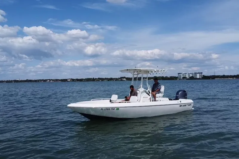Slide: The Image of 2022 Skeeter SX2250 boat on calm water under a partly cloudy sky. - 18