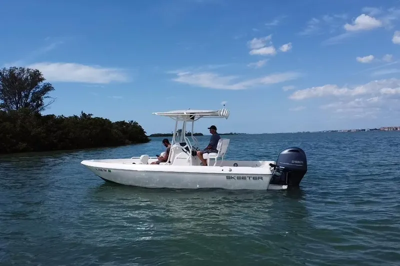 Slide: The Image of 2022 Skeeter SX2250 boat on calm water with two people onboard. - 19