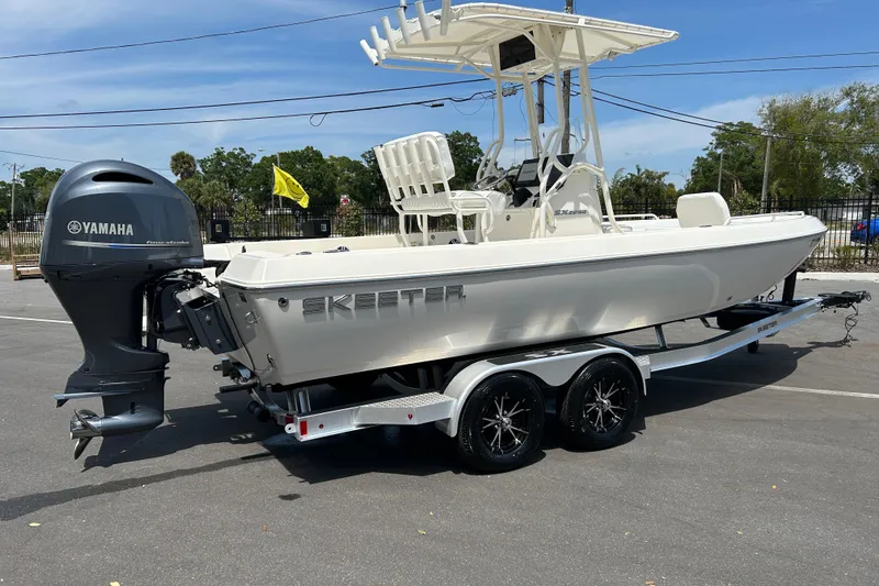 Slide: The Image of 2022 Skeeter SX2250 boat with Yamaha engine on a trailer in a parking lot. - 2
