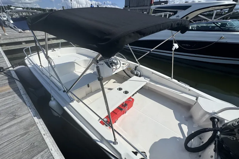 Slide: The Image of A 2027 Boston Whaler 160 Super Sport docked. It features a black sunshade. - 10