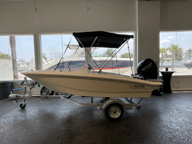 Slide: The Image of A 2026 Boston Whaler 130 Super Sport on a trailer in a showroom. - 0