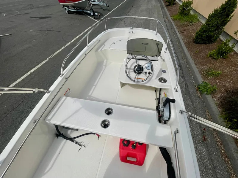 Slide: The Image of The image shows the cockpit of a 2027 Boston Whaler 130 Super Sport. It features a simple helm and a red fuel tank. - 4