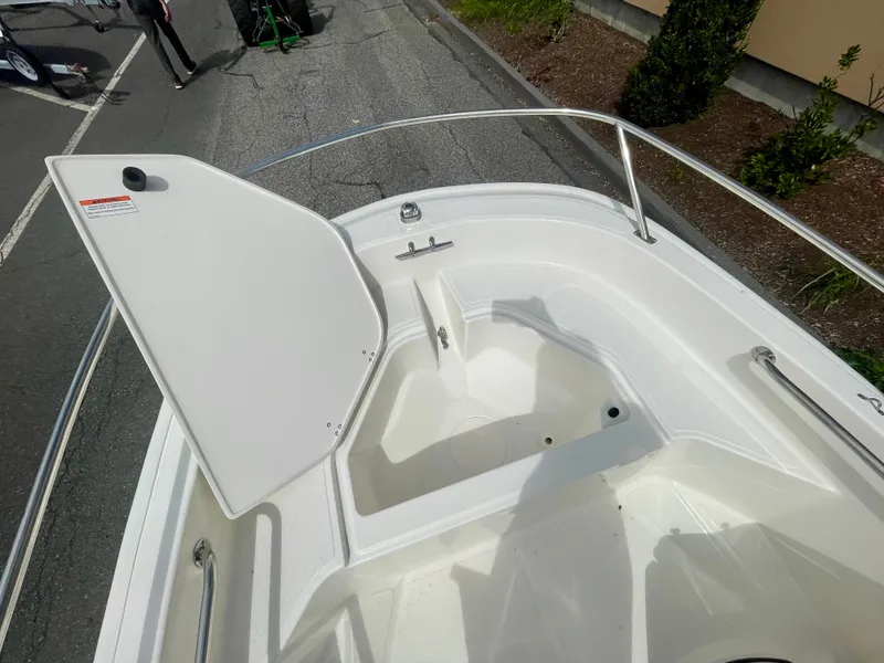 Slide: The Image of The image shows the bow area of a 2027 Boston Whaler 130 Super Sport with storage space. - 12