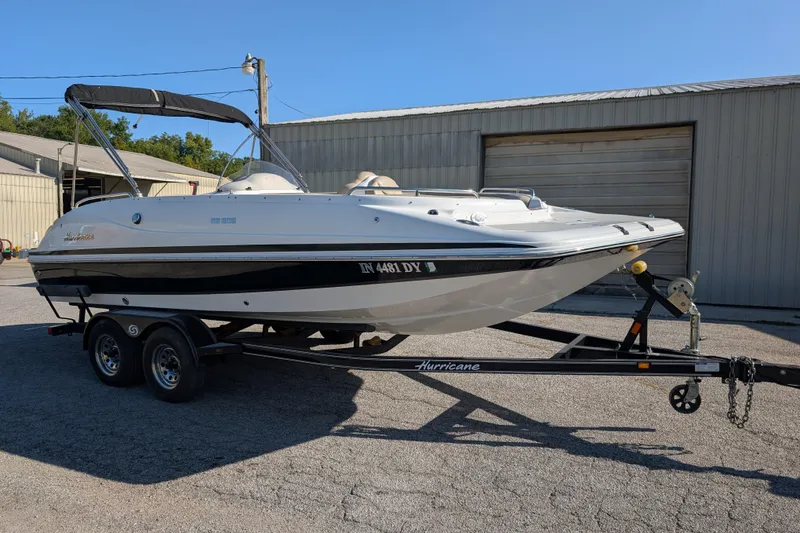 The Image of 2017 Hurricane SunDeck Sport 202 IO boat on trailer, parked outside a warehouse. - 0