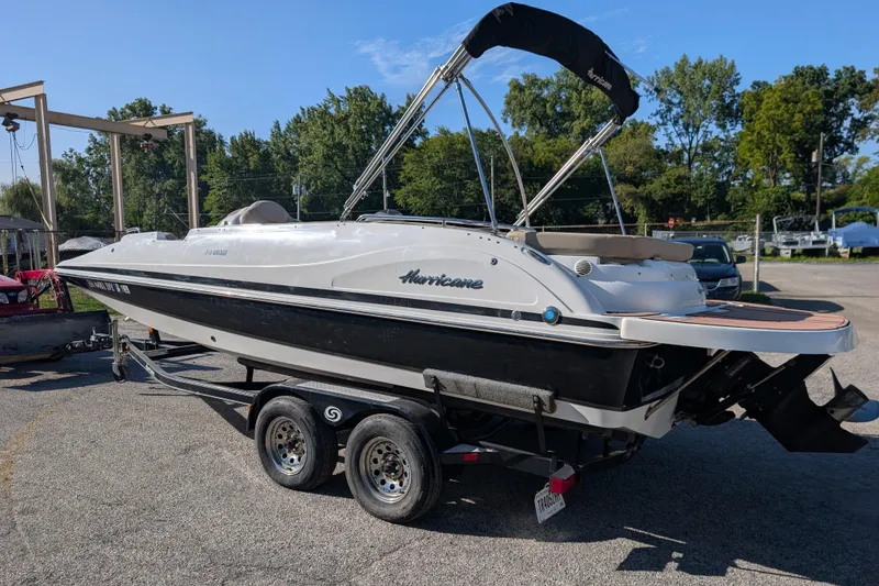 Slide: The Image of 2017 Hurricane SunDeck Sport 202 IO boat on trailer, parked outdoors under clear sky. - 15