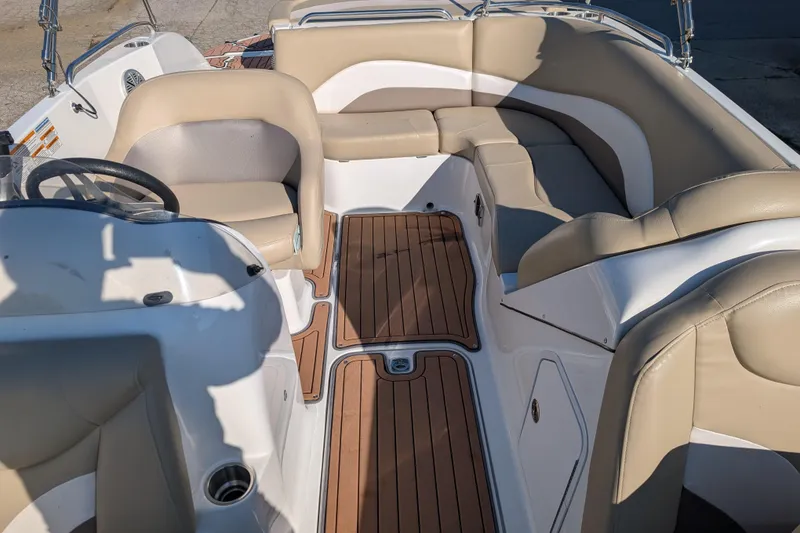 Slide: The Image of 2017 Hurricane SunDeck Sport 202 IO interior with beige seating and wood-style flooring. - 9