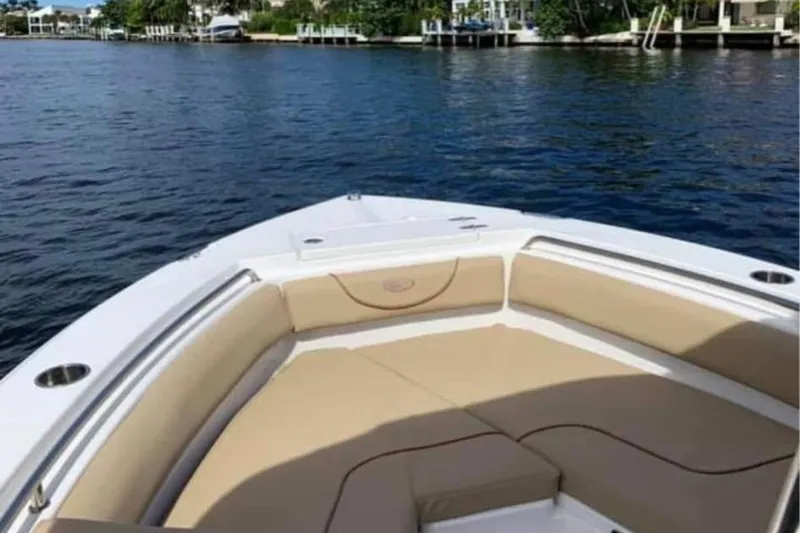Slide: The Image of 2018 Sea Hunt Ultra 211 boat with beige seating, cruising on a calm waterway. - 4