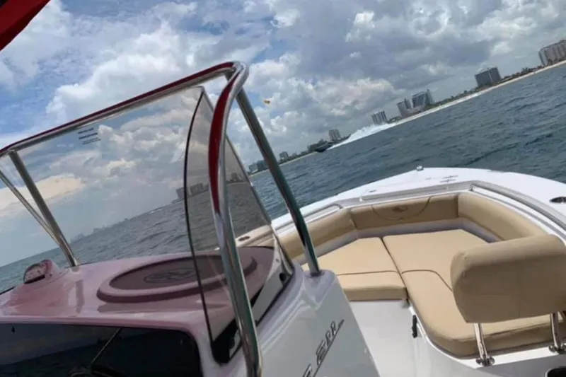 Slide: The Image of 2018 Sea Hunt Ultra 211 boat cruising on ocean with city skyline in background. - 6